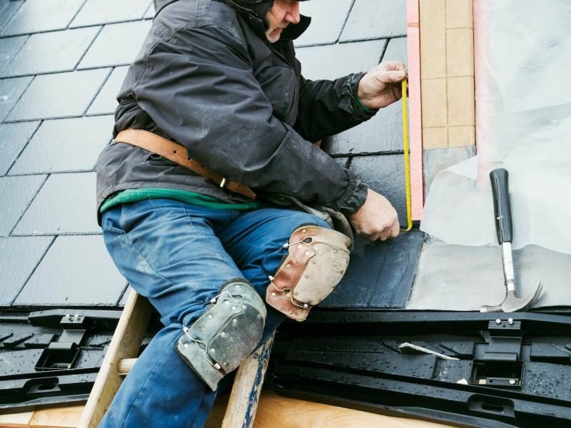a-man-at-the-top-of-a-ladder-on-a-house-roof-fixing-tiles-on-a-dormer-roof-1-1.jpg